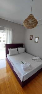 a bedroom with a large bed with white sheets and a chandelier at Sea flight in Preveza