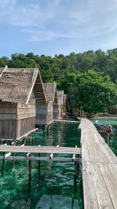 a group of huts on a dock in the water at Gibran guest house in Kri