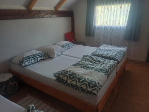 1 dormitorio con 2 camas individuales y almohadas en Holiday Home Edi, en Bihać