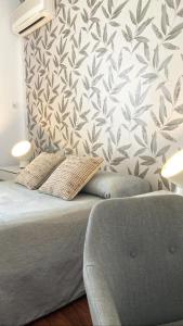 a bedroom with a bed and a wall with a leaf pattern at Las Américas - Mares in Torre del Mar