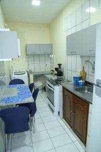 uma cozinha com uma mesa e cadeiras azuis em Apartamento excelente Marabá em Marabá