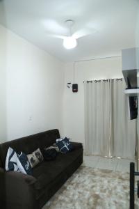 uma sala de estar com um sofá preto e uma ventoinha de tecto em Apartamento excelente Marabá em Marabá