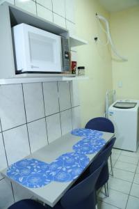 a kitchen with a table with a microwave above it at Apartamento excelente Marabá in Marabá