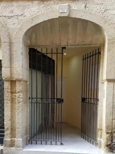 una entrada a un edificio con puerta de hierro en Appart 40m2 indépendant, confortable avec terasse, en Lunel