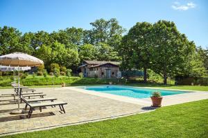 a swimming pool with a picnic table and an umbrella at Podere Lamberto in Montepulciano
