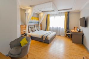 Habitación de hotel con cama y silla en Raha Suites - Westlands 