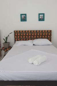 uma cama branca com duas toalhas em cima em Terraço Ribeira Casa p Temporada em Salvador