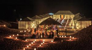メルズーガにあるMerzouga Sahara Luxury Campの蝋燭の建物前に立つ集団