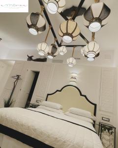 een slaapkamer met een groot wit bed met verlichting bij AMAREA Exclusive Suites in San Felice Circeo