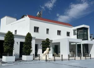 a white building with a statue in front of it at DON LEONE Hotel in Alginet