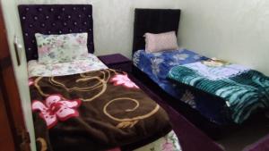two beds sitting next to each other in a room at ADAM 2 in Dakhla