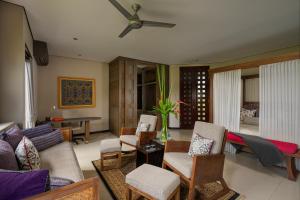 sala de estar con sofá, sillas y ventilador de techo en Luxe Villas Bali, en Ubud
