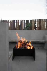 a fire in a box in front of a bench at Casa Michaus Valle de Guadalupe in Valle de Guadalupe