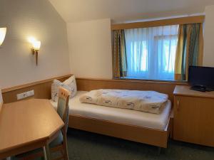 a room with a bed and a desk and a window at Landgasthaus zum Hirsch in Ramsen