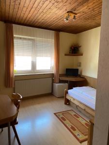 a bedroom with a bed and a desk and two windows at Landgasthaus zum Hirsch in Ramsen +4 photos