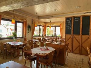 un restaurante con mesas y sillas y una pizarra en Landgasthaus zum Hirsch en Ramsen