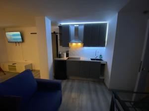 a living room with a kitchen with a blue light at Loft, muy cerca de playa y castillo Tamarit in Tarragona