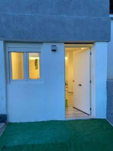 a white garage with a door and a window at Loft, muy cerca de playa y castillo Tamarit in Tarragona