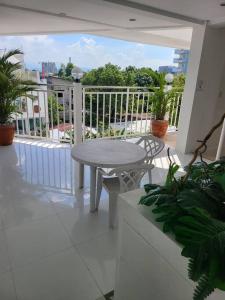 a white balcony with a table and chairs on a patio at Sheryll Escapes - Kandi comfortable 1bedroom, king bed, housekeeping in Angeles