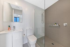 a white bathroom with a toilet and a shower at Fully equipped apartment in Rockdale in Sydney +4 photos