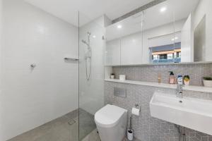 uma casa de banho com um chuveiro, um WC e um lavatório. em Entire home in Wolli Creek em Sydney