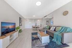 a living room with a couch and a tv at Fully equipped apartment in Rockdale in Sydney