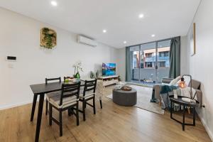uma sala de jantar e sala de estar com mesa e cadeiras em Entire home in Wolli Creek em Sydney