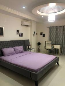 a bedroom with a large purple bed and a desk at Sheryll Escapes - Kandi comfortable 1bedroom, king bed, housekeeping in Angeles