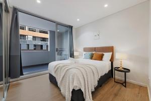 a bedroom with a large bed and a large window at Entire home in Wolli Creek in Sydney