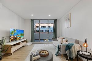 a living room with a couch and a tv at Entire home in Wolli Creek in Sydney