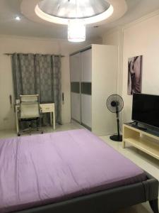 a bedroom with a large purple bed and a television at Kandi comfortable 1bedroom, king bed, housekeeping in Angeles