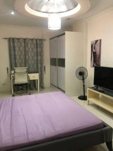 a bedroom with a large purple bed and a television at Sheryll Escapes - Kandi comfortable 1bedroom, king bed, housekeeping in Angeles +16 photos