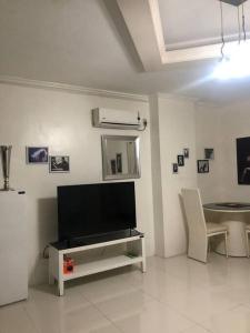 a living room with a flat screen tv and a table at Kandi comfortable 1bedroom, king bed, housekeeping in Angeles