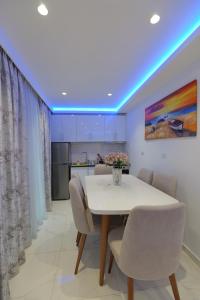 une salle à manger avec une table et des chaises blanches dans l'établissement Twins Villa, à Saranda