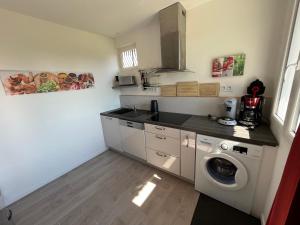 a kitchen with a washing machine and a washer at Le Verger Grimaldin in Grimault