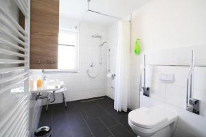een witte badkamer met een toilet en een wastafel bij Ferienwohnungen Hafenresidenz Alter Speicher Lauterbach in Putbus