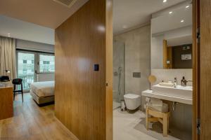 a bathroom with a sink and a toilet and a bed at Acta The Clover in Porto