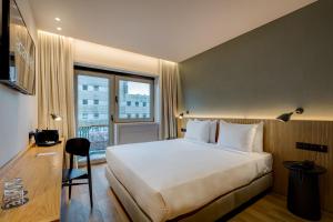 a hotel room with a large bed and a window at Acta The Clover in Porto