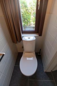 La salle de bains est pourvue de toilettes et d'une fenêtre. dans l'établissement Gastenkamers Ten Huyze Marchandise, à Bruges