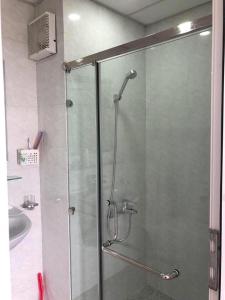 y baño con ducha y puerta de cristal. en Homestay Bai Chay Ha Long ( Ocean View) en Ha Long