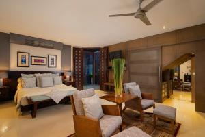 1 dormitorio con 1 cama, mesa y sillas en Luxe Villas Bali, en Ubud