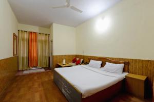 a bedroom with a large bed and a window at OYO Hotel Sunbeam in Shamshi