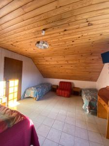 a room with two beds and a wooden ceiling at Ferme-auberge le cochon du Madres in Escouloubre