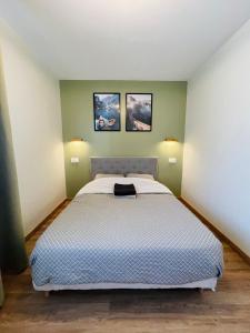 - une chambre avec un lit et 2 photos sur le mur dans l'établissement T2 Tête d’Or Confort + Parking gratuit, à Villeurbanne