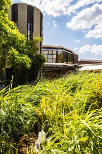 a building with tall grass in front of a building at Thermalhotel Kemper in Erwitte