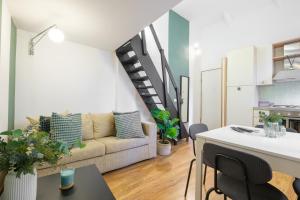 a living room with a couch and a staircase at Green Coast House 5 in Piombino
