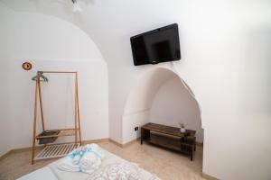 1 dormitorio con TV en la pared y 1 cama en Casa GianAngel Ostuni en Ostuni