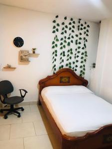 1 dormitorio con cama, escritorio y silla en hostal la 18, en Pereira