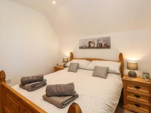 a bedroom with a bed with two pillows on it at Oak Tree House, 1 Homestead Gardens in Filby
