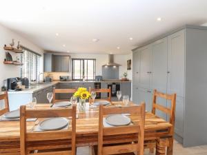 a kitchen and dining room with a wooden table and chairs at Oak Tree House, 1 Homestead Gardens in Filby